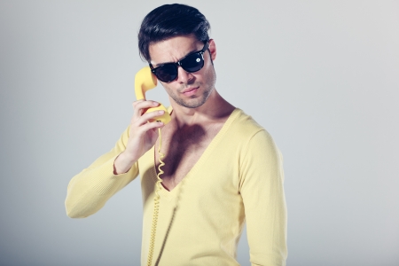 funny call center guy with hipster glasses and colouful phonesの写真素材