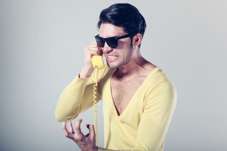 funny call center guy with hipster glasses and colouful phonesの写真素材