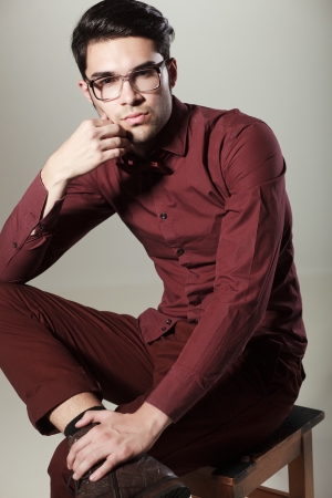 handsome man dressed elegant posing in the studio looking seriousの写真素材