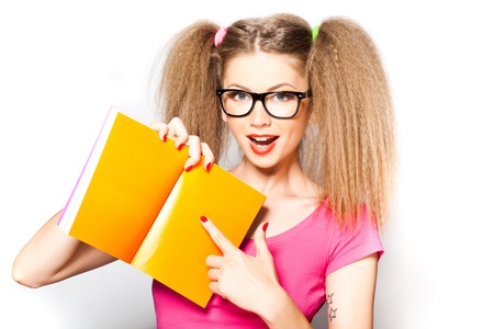 curly girl wearing glasses pointing at an opened book isolated on white 