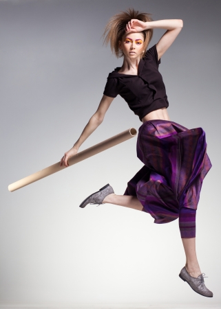 sexy woman model jumping in large pants - studio fashion shotの写真素材