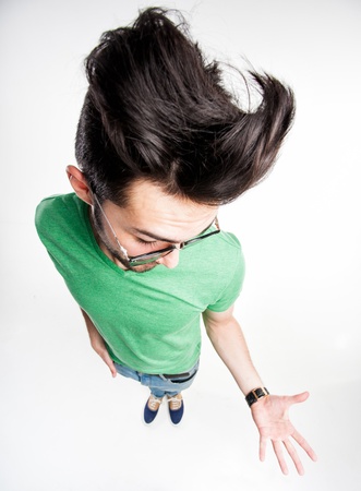 funny man with wierd hairstyle showing his palm - wide angle shotの写真素材