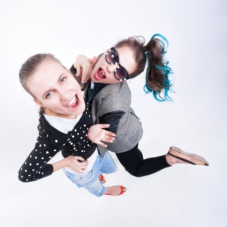 two girls making funny faces - isolated on bluish backgroundの写真素材