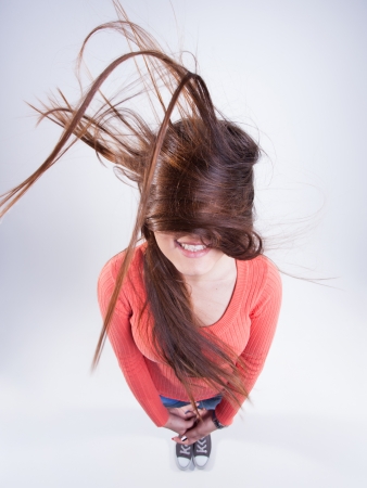 pretty girl with long hair blowing in the wind smilingの写真素材