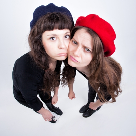 two cute girls having fun and making funny facesの写真素材