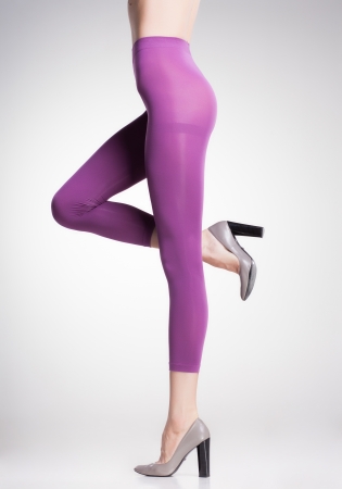 violet pink tights on sexy woman legs isolated on greyの写真素材