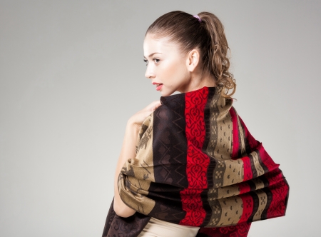 beautiful woman wearing colorful kashmir scarf isolated on grey - landscape, copy-spaceの写真素材