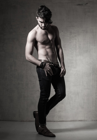 sexy fashion man model top naked posing dramatic against grunge wallの写真素材