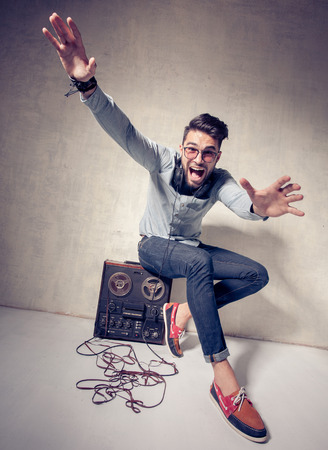 handsome man listening to music on a magnetophone against grunge wallの写真素材