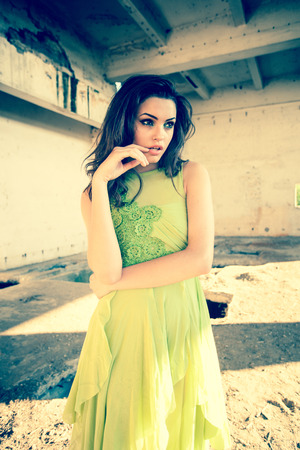 beautiful model in green dress posing in grunge locationの写真素材