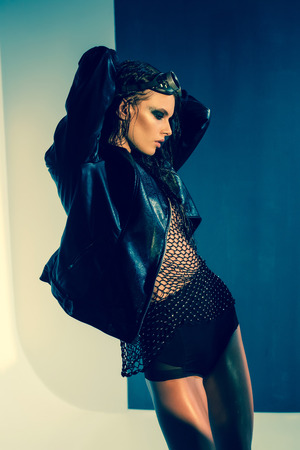 sexy woman model dressed punk, wet look, posing in the studioの写真素材