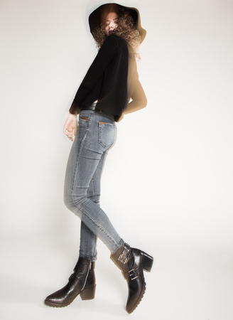 pretty woman posing in denim pants and boots and black hat - intentional motion blurの写真素材