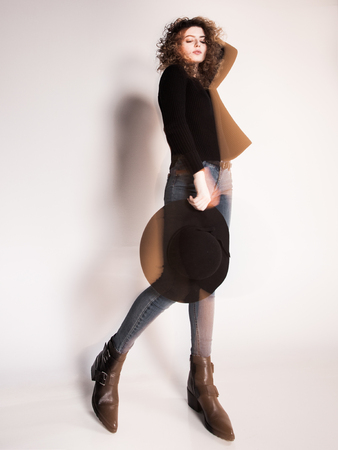 pretty woman posing in denim pants and boots and black hat - intentional motion blurの写真素材