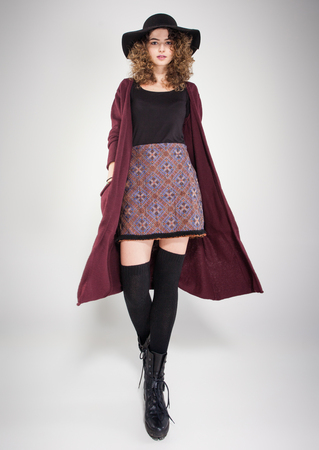 pretty woman with curly hair dresed casual posing in the studioの写真素材