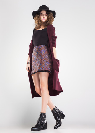 pretty woman with curly hair dresed casual posing in the studioの写真素材