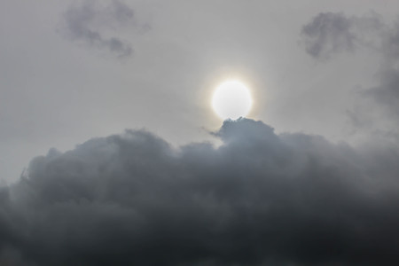 Sun behind a fluffy Cloudの写真素材