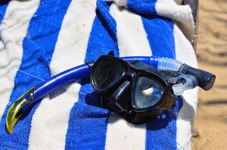 diving mask with snorkel and beach towelの写真素材