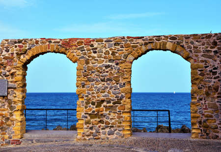 archivolt and glimpse of the sea in cefalu sicily italyの写真素材