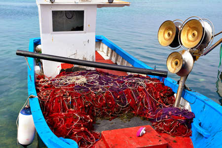 fishing nets on the characteristic wooden boats in porto cesareo italyの写真素材
