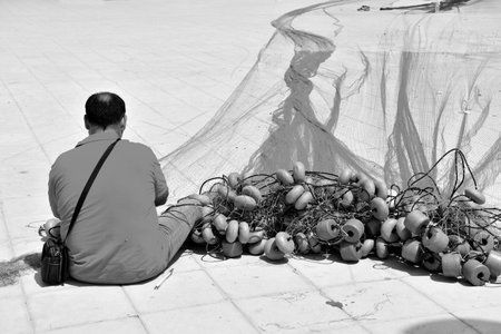 fisherman in the harbor April 29 2018 Porto Cesareo Italyのeditorial素材