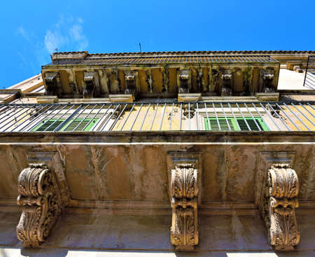 Balcony with typical baroque sculptures in Modica, Sicily, Italyの写真素材