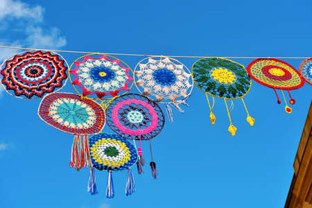 colored crochet lace as embellishment and street furniture in the historic center of castellammare del golfo italyの写真素材