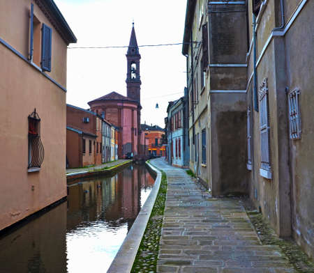 Small Italian town Comacchio also known as "The Little Venice", Emilia Romagna region, province of Ferrara, Italy: Colored houses in traditional architectural styleの写真素材