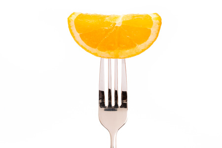 Concept of vegetarian food. Orange on forkの写真素材