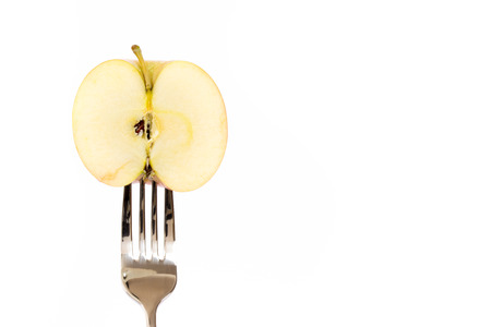 Concept of vegetarian food. Apple on forkの写真素材