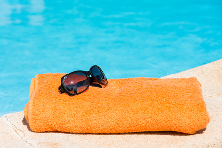 Towel sunglasses and smartphones in the pool