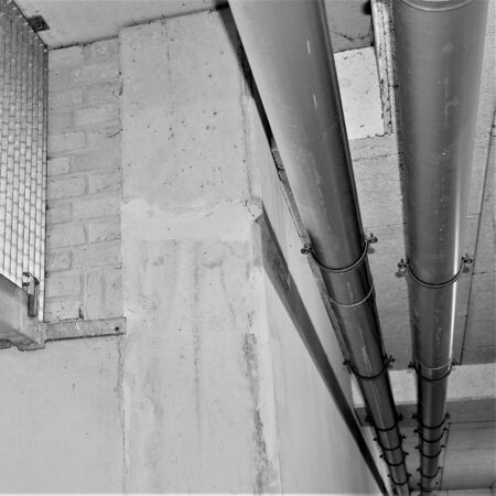 Industrial environment with metal grid concrete wall and pipelinesの写真素材