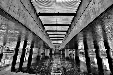 Black and white picture with abstract concrete pillars underneath a railway bridge in the center of Amersfoortの写真素材