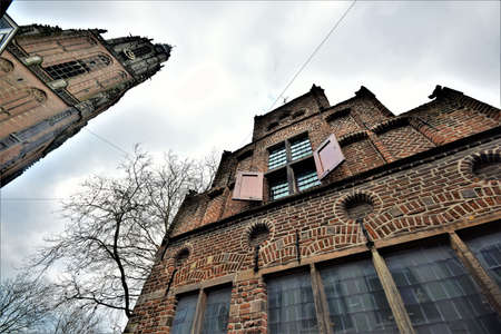 Wide angle frog perspective picture with monumental historical tower and house