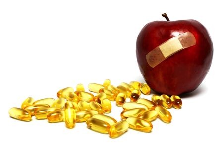 A plastered red apple and many capsulesの写真素材