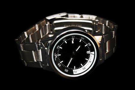 Close-up of a handwatch over black background.