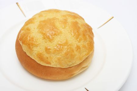 Pineapple bun (Hong Kong pastry) on white plate.