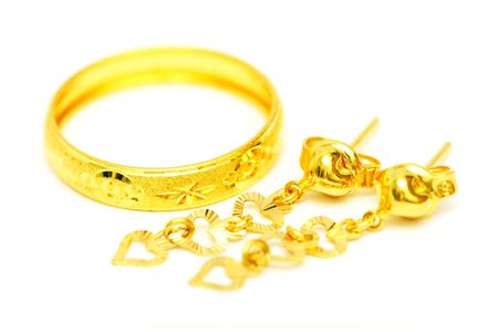 A golden ring and earrings isolated on white background.の写真素材