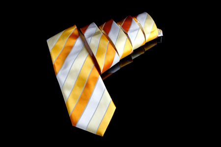 An orange necktie with stripes on black background.の写真素材
