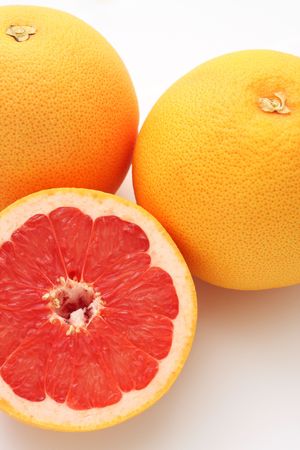 Close up of two and half grapefruits isolated on white background.の写真素材