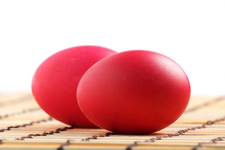 Close up of two red eggs on bamboo mat.の写真素材