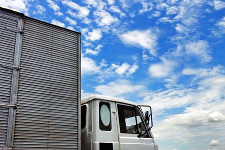 A truck drive over cloudy blue sky on a sunny day.の写真素材