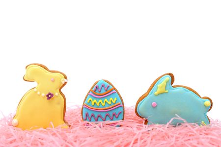 Close up of easter cookies on pink ribbons over white background.の写真素材