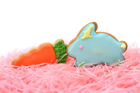 Close up of easter cookies on pink ribbons over white background.
