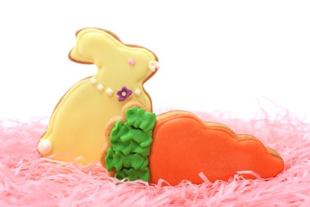 Close up of easter cookies on pink ribbons over white background.