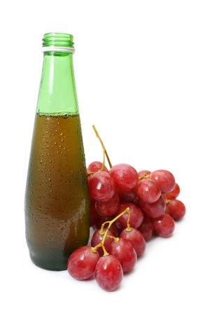 A string of red grapes beside wine bottle.の写真素材