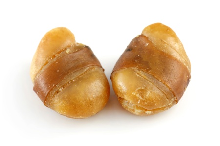 Close up of two seasoned horse beans isolated on white background.