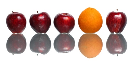 An orange being standout among red apples isolated on white background.の写真素材