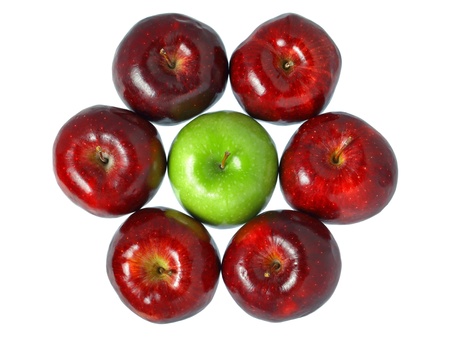 A green apple put in the middle of red apples isolated on white background.の写真素材