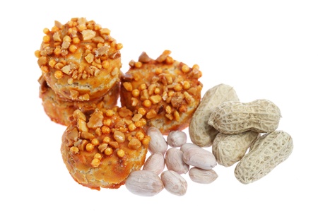 Close up of coated cookie and peanuts isolated on white background.