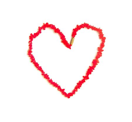 coral beads in the shape of a heart on a white backgroundの写真素材